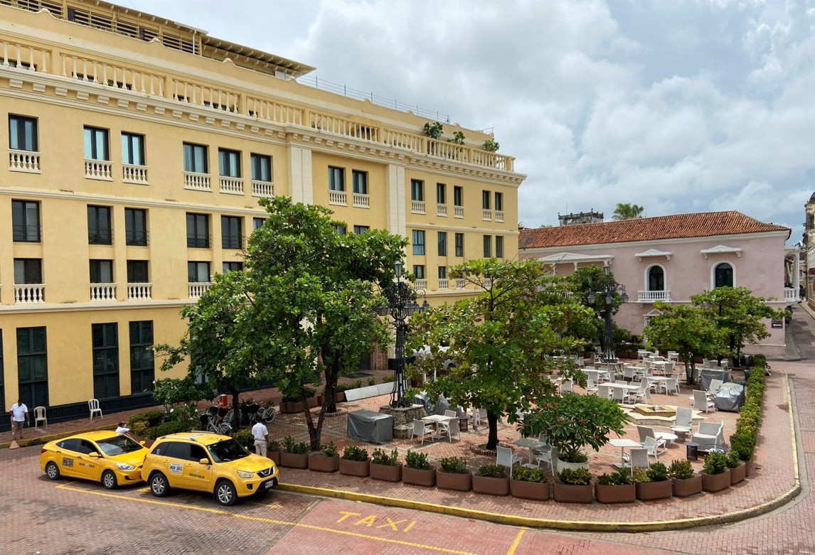 Yellow taxis beside a colonial plaza in Cartagena
